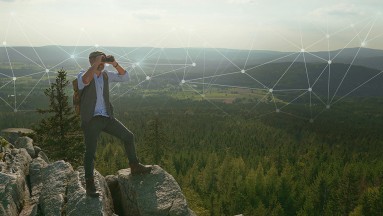 Wanderer im Vordergrund mit Fernglas, im Hintergrund das Fichtelgebirge, Wald und am Himmel ein grafisches Netzelement 