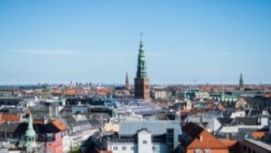 Panoramic view over the rooftops of Copenhagen with the striking church tower of Christiansborg Palace in the background