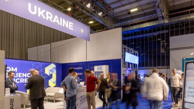 links der Gemeinschaftsstand der Ukraine auf der Smart Country Convention 2023, rechts Teilnehmerinnen und Teilnehmer