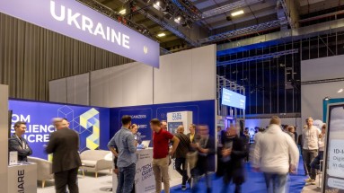 Messestand der Ukraine auf der Smart Country Convention 2023, im Vordergrund Teilnehmende