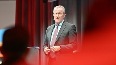 Nordirlands Wirtschaftsminister Conor Murphy hält auf der Bühne eine Keynote