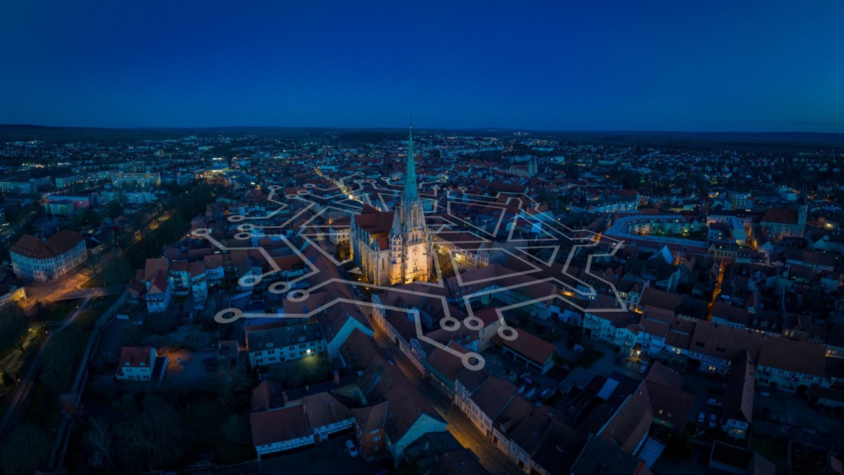 Night shot of the town of Mühlhausen with a graphic network in the centre