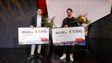 The winners of the Smart Country Startup Award with large cheques and a bouquet of flowers in their hands.