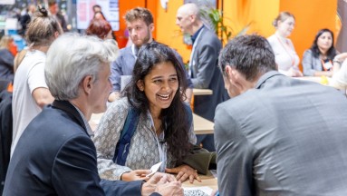 Career Lounge der Smart Country Convention, im Vordergrund: Junge Frau im Austausch mit einer Frau und einem Mann