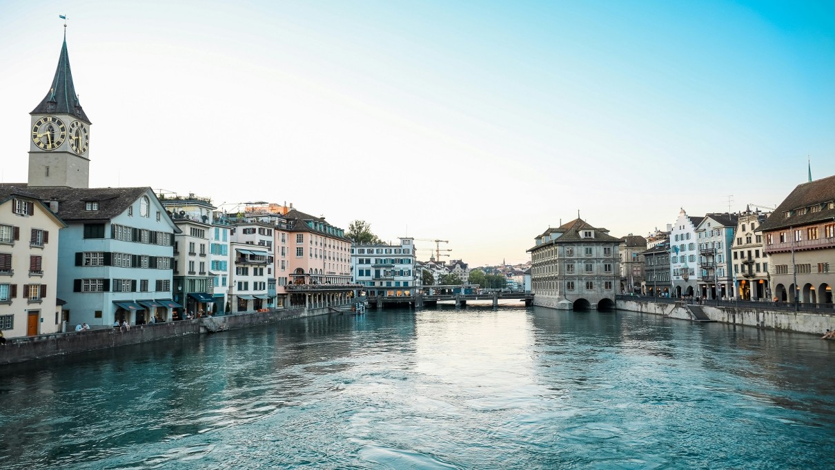 Buildings and church steeples near a river. 