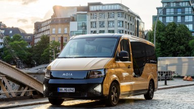 An autonomous vehicle in the foreground. In the background, a city view of Hamburg.