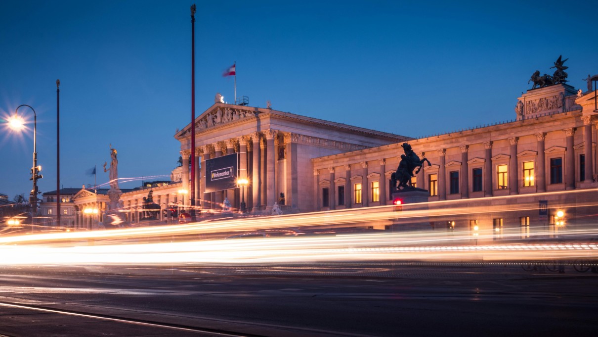 Beleuchtete Gebäude und Straße bei Nacht.