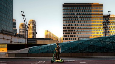 Street with futuristic buildings and e-scooters. 