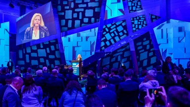 Bundesinnenministerin Nancy Faeser auf der Bühne der Smart Country Convention an einem Rednerpult. Im Vordergrund das Publikum. 